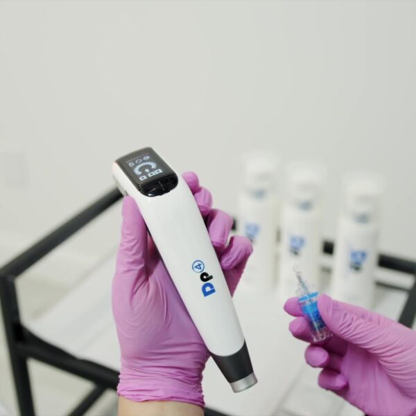 appareil dermapen de microneedling avec cartouche d'aiguilles présenté par l'esthéticienne dans la salle de soins