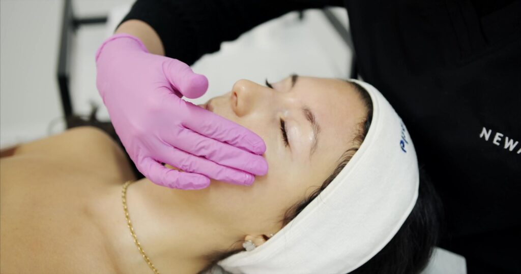 ESTHETICIAN TOUCHING FACE DURING CONSULTATION